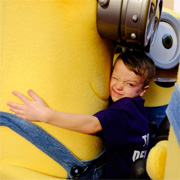 Boy cuddling a Minion at Toy Fair